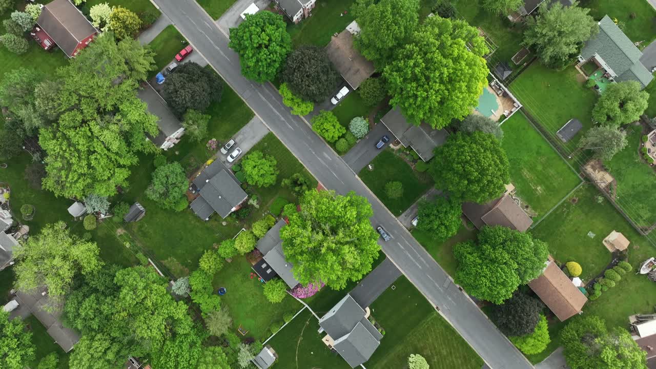Giardino con erba verde di case unifamiliari nella periferia americana. Sorvolo aereo dall'alto. Alberi primaverili in un'area residenziale di classe media. Comunità pittoresca e tranquilla negli Stati Uniti.
