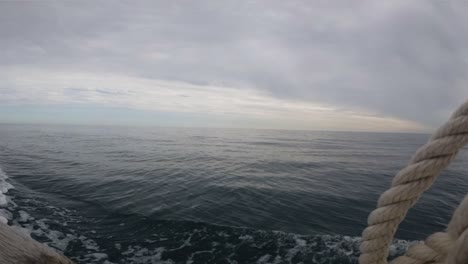 Sailing-with-boat-in-open-sea-with-stormy-clouds,-static-view