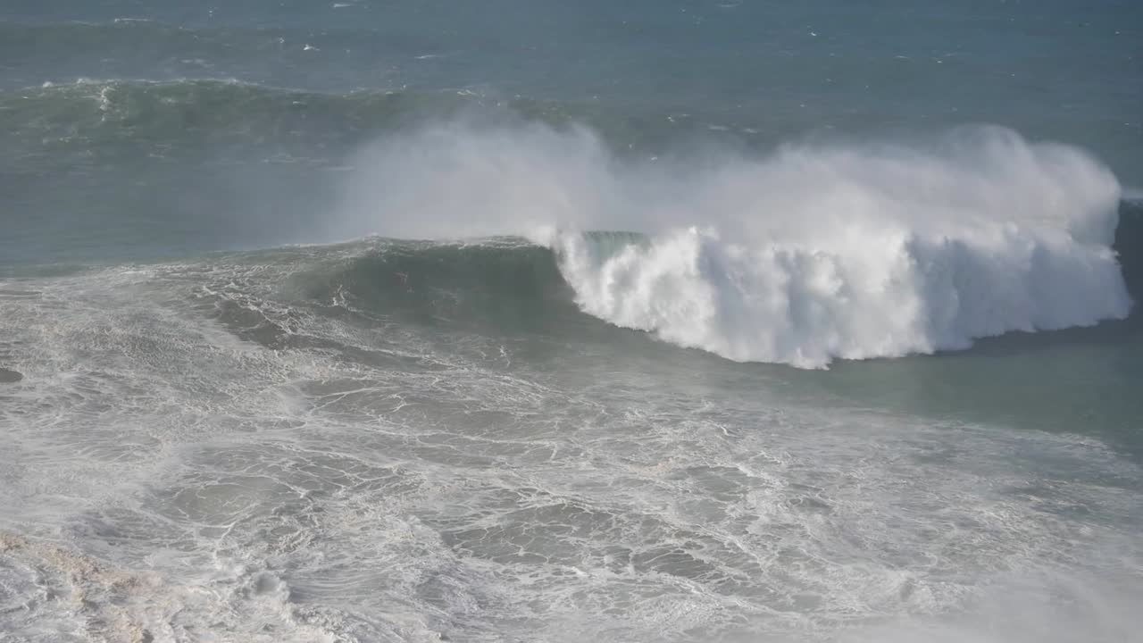 Powerful waves crashing at Nazaré, Portugal, showcasing ocean force and beauty