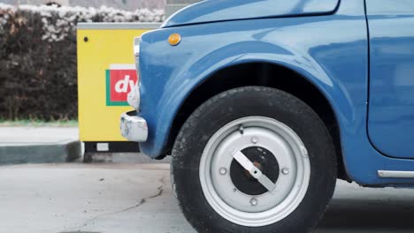 fiat 500 vintage car pulls up to petrol filling station