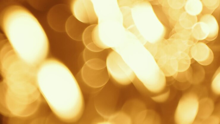 Luci bokeh dorate in movimento su sfondo scuro