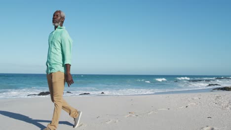 senior man walking besides the beach