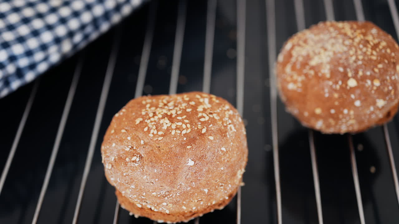 Close up of rye bread rolls on an oven grill tray