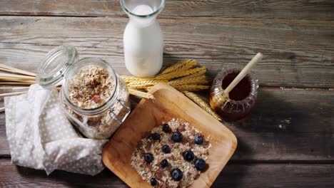 cereales para el desayuno y un frasco de miel en una mesa de madera 4k