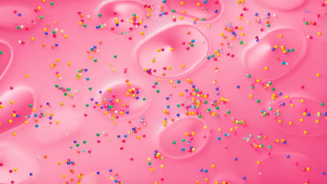 colorful sprinkles on a pink surface