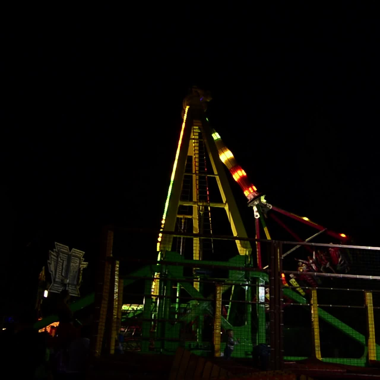 Amusement Fair Park At Night. Holiday night amusement park with flashing lights illumination with swings