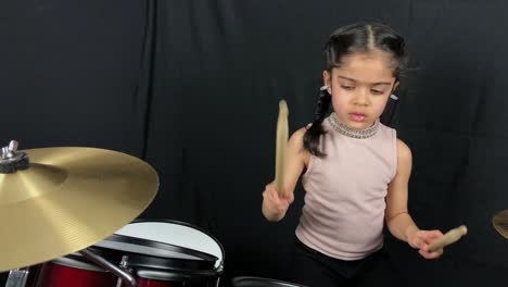 5 year old girl practicing on the drums