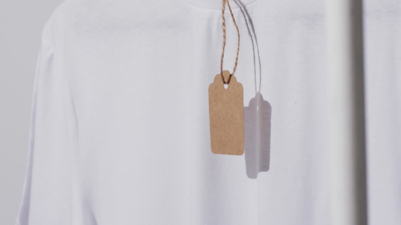 video di una maglietta bianca con tag e spazio di copia su sfondo bianco