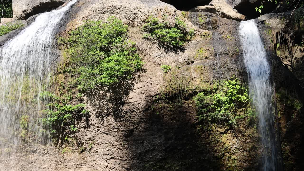 una cascada que cae en cascada por un acantilado rocoso
