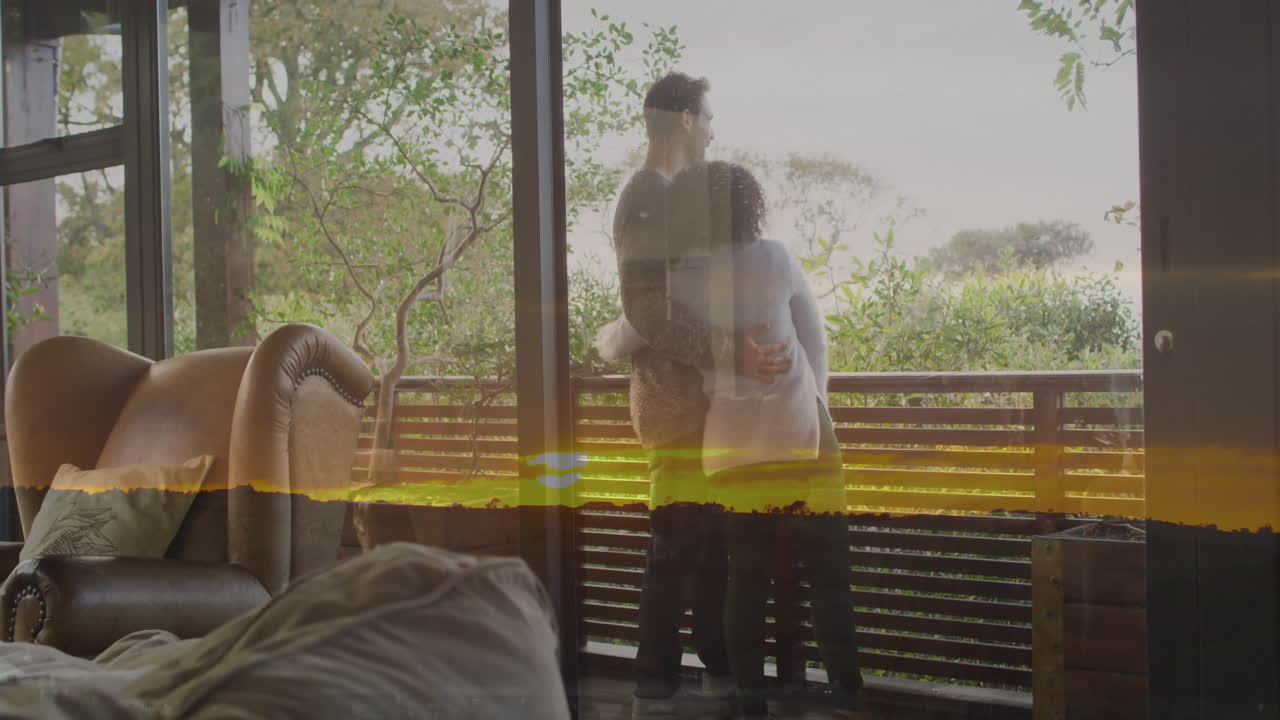 Couple embracing on balcony with scenic landscape animation through glass
