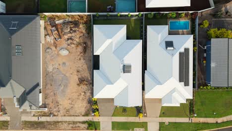 vista aérea de un exterior de una casa de exhibición con líneas modernas limpias, grandes ventanas y paisajismo circundante