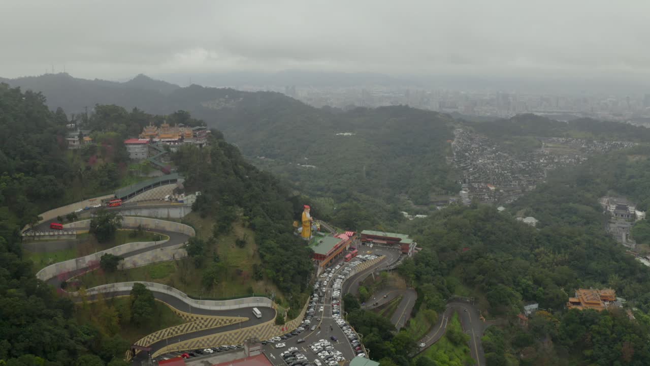 Taipei, Çin dışında yer alan, yemyeşil süslü bir dağ tapınağına giden geçide ve bir heykele doğru havadan görünüm.