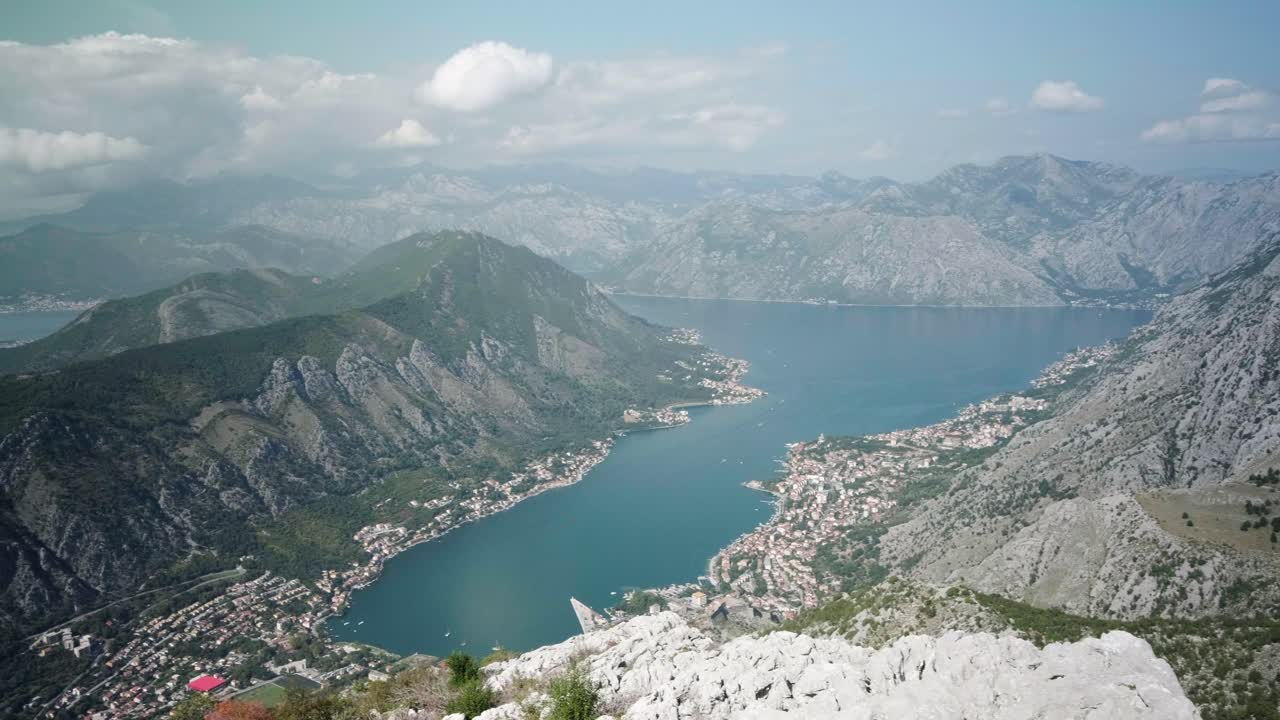 Sonbahar mevsiminde güneşli bir günde, Karadağ'daki Kotor Körfezi'ne bakan bir seyir noktasında oturan güzel bir bayan.