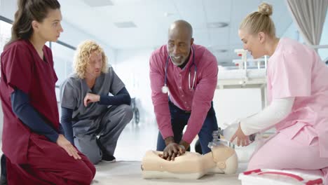 african american doctor training trainee doctors in emergency cpr procedure using dummy, slow motion