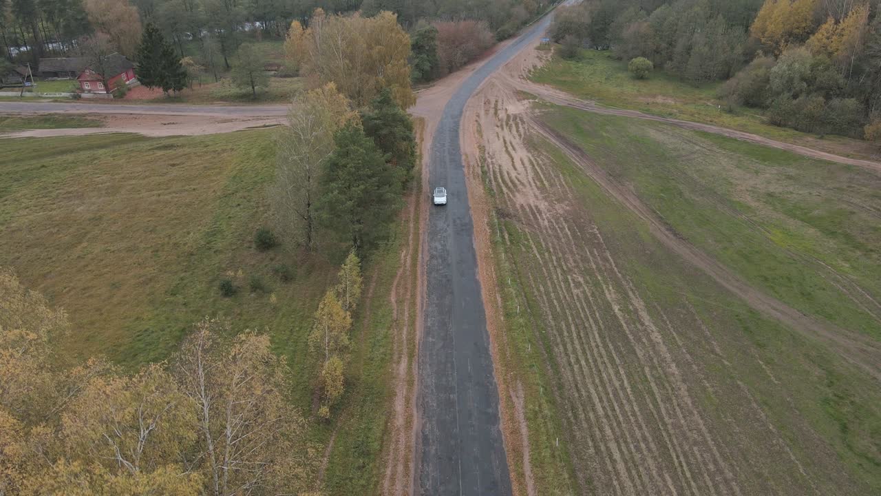 시골 도로에서 운전하는 색 전기 자동차의 항공 시각. 시골 고속도로를 지나가는 현대 차량.