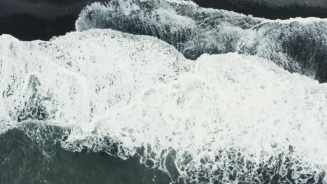 Top-down-of-famous-black-volcanic-sand-beach-in-Iceland-with-waves