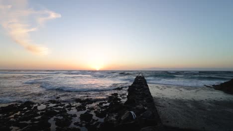 Hermosa-Puesta-De-Sol-En-El-Horizonte-Con-Olas-De-Ensueño-Llegando-A-La-Costa,-Tenerife