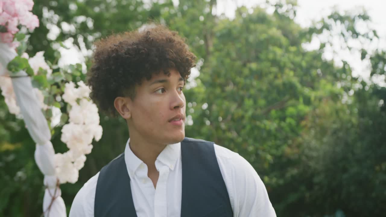 feliz hombre biracial en el jardín en un día soleado en la boda