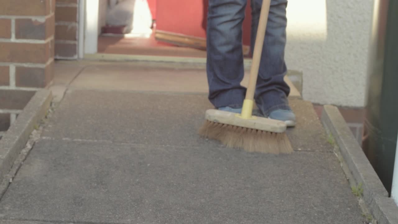 Sweeping the pathway with broom