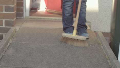 sweeping the pathway with broom
