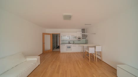 a light and airy studio apartment featuring elegant white furniture and a modern kitchen. the open-plan layout enhances the spacious feel, making it a perfect urban living space.