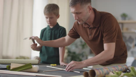 father and son making a kite together