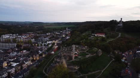 Ruinas-Del-Castillo-En-La-Cima-De-Una-Colina-Rodeada-Por-El-Municipio-De-Valkenburg,-Vista-Aérea