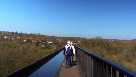 Una-Pareja-De-Ancianos-Con-Canas-Camina-Por-El-Famoso-Acueducto-Pontcysyllte-En-La-Ruta-Del-Canal-Llangollen-En-La-Hermosa-Campiña-Galesa