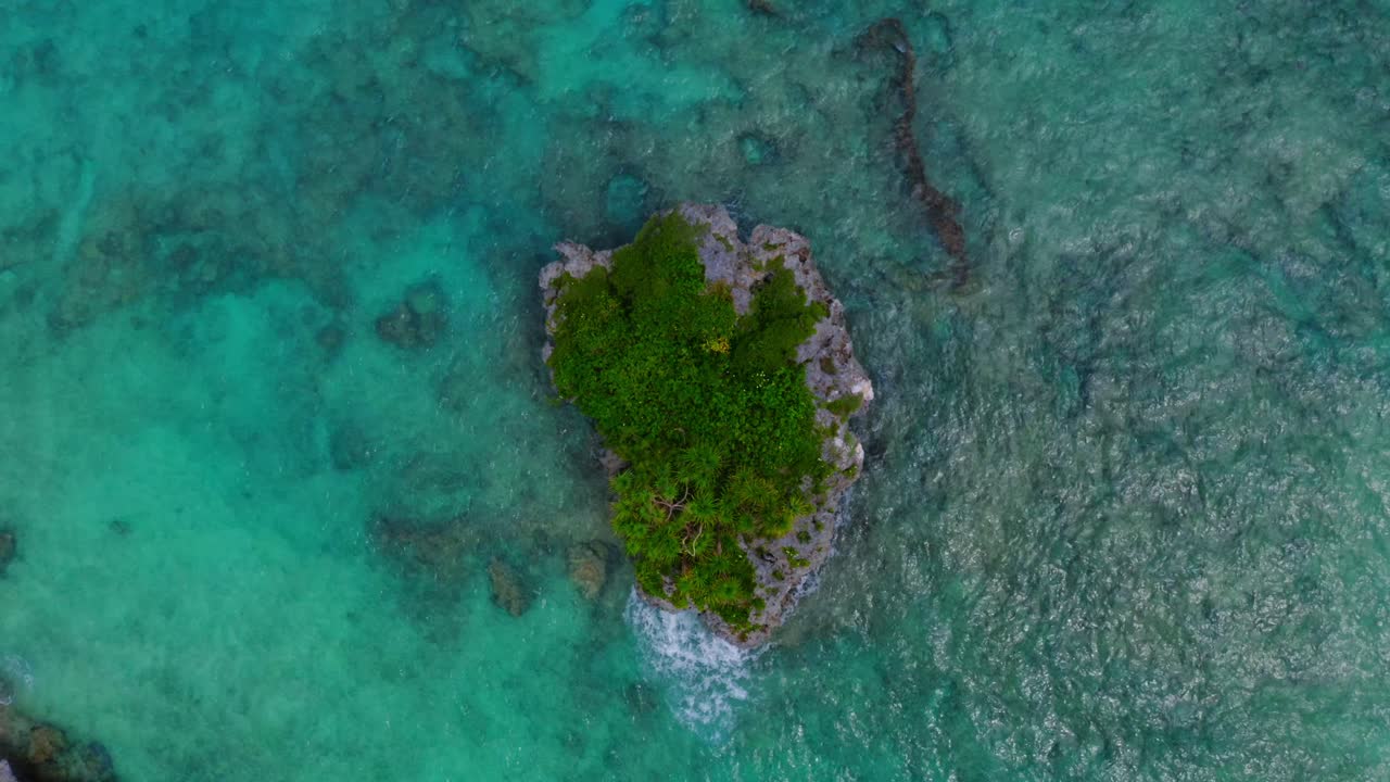 무인 항공기는 블루 라군에 있는 작은 바위 섬의 조감도를 캡처하여 외딴 외딴 섬에 대한 독특한 관점을 제공합니다.
