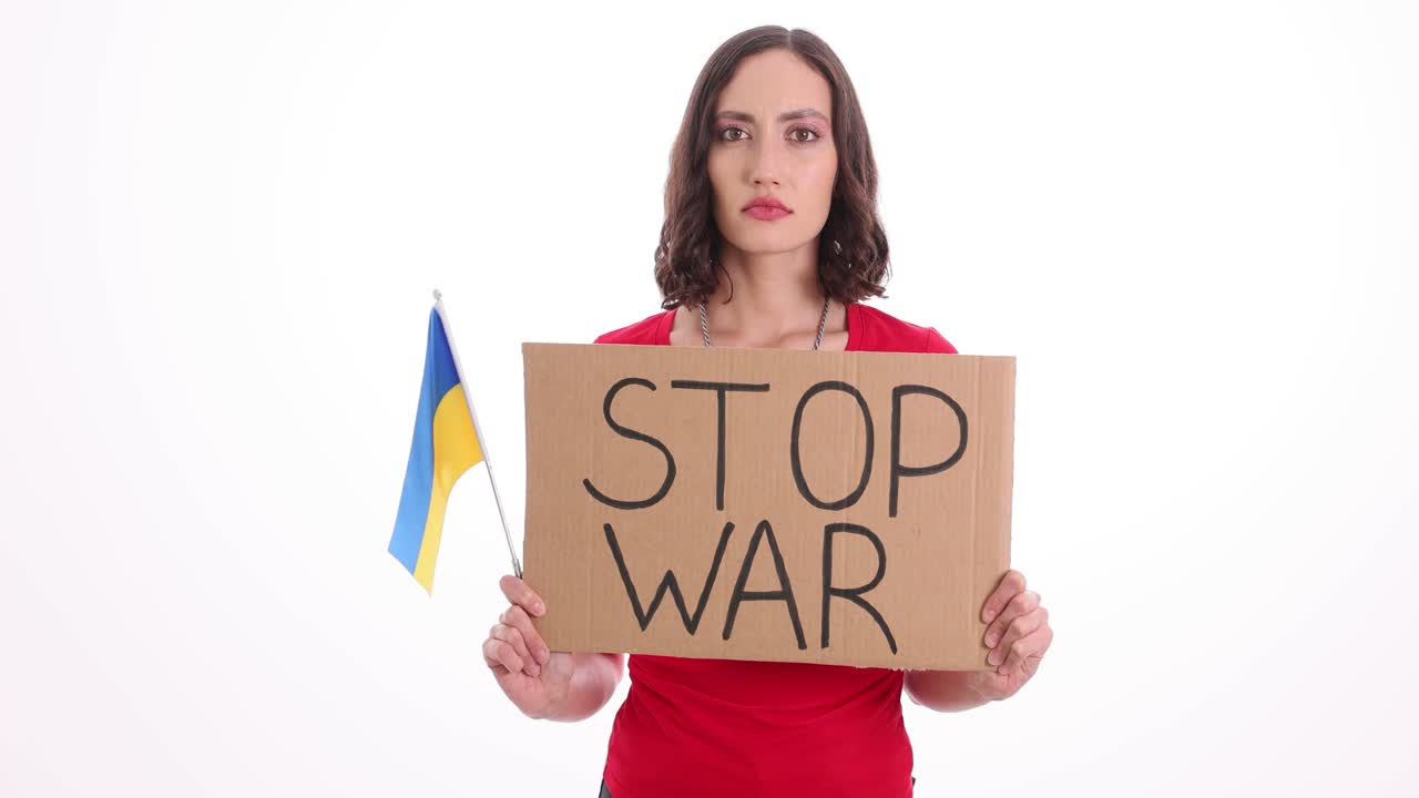 Woman holding a 'STOP WAR' sign and Ukrainian flag