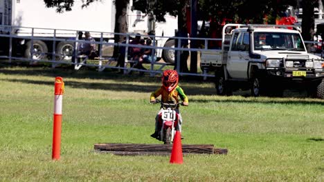 child competes in motocross event, showcasing skill.