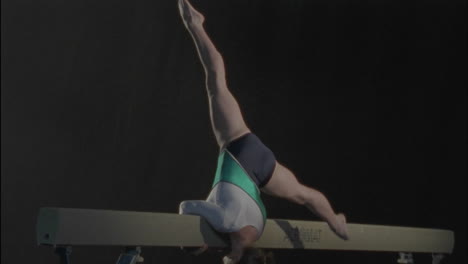 a female gymnast performs a routine on the bar