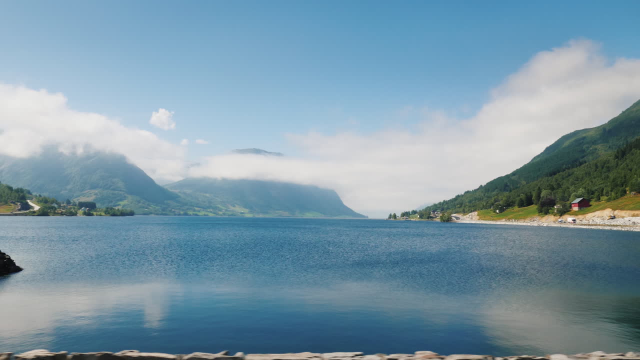 피요르드의 해안 산 정상은 t의 창에서 볼 구름에 익사하고 있습니다