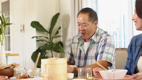 eating together, family enjoying meal with chopsticks and bamboo steamer at table