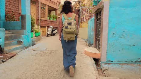 female tourist walks through the streets of an indian city. rajasthan, indian jodhpur also blue city