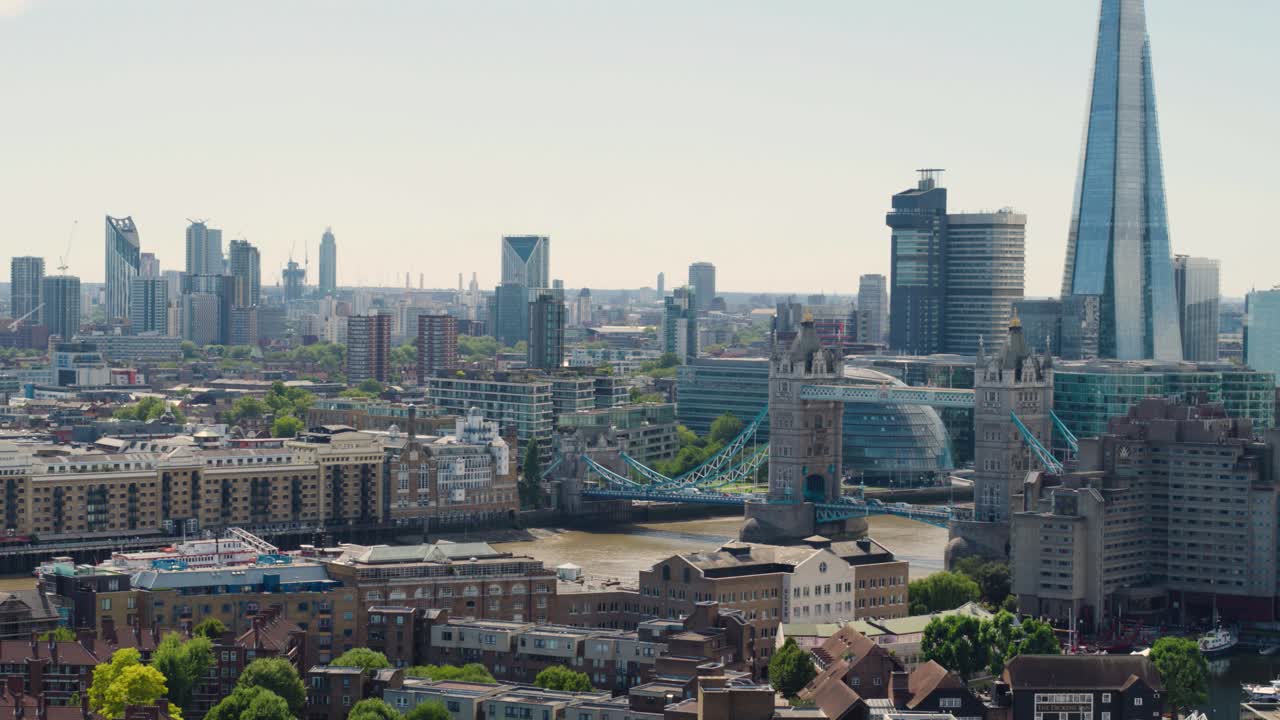 Panning aerial shot over Central London overlooking the historic Tower Bridge and The Shard on a bright summer morning.