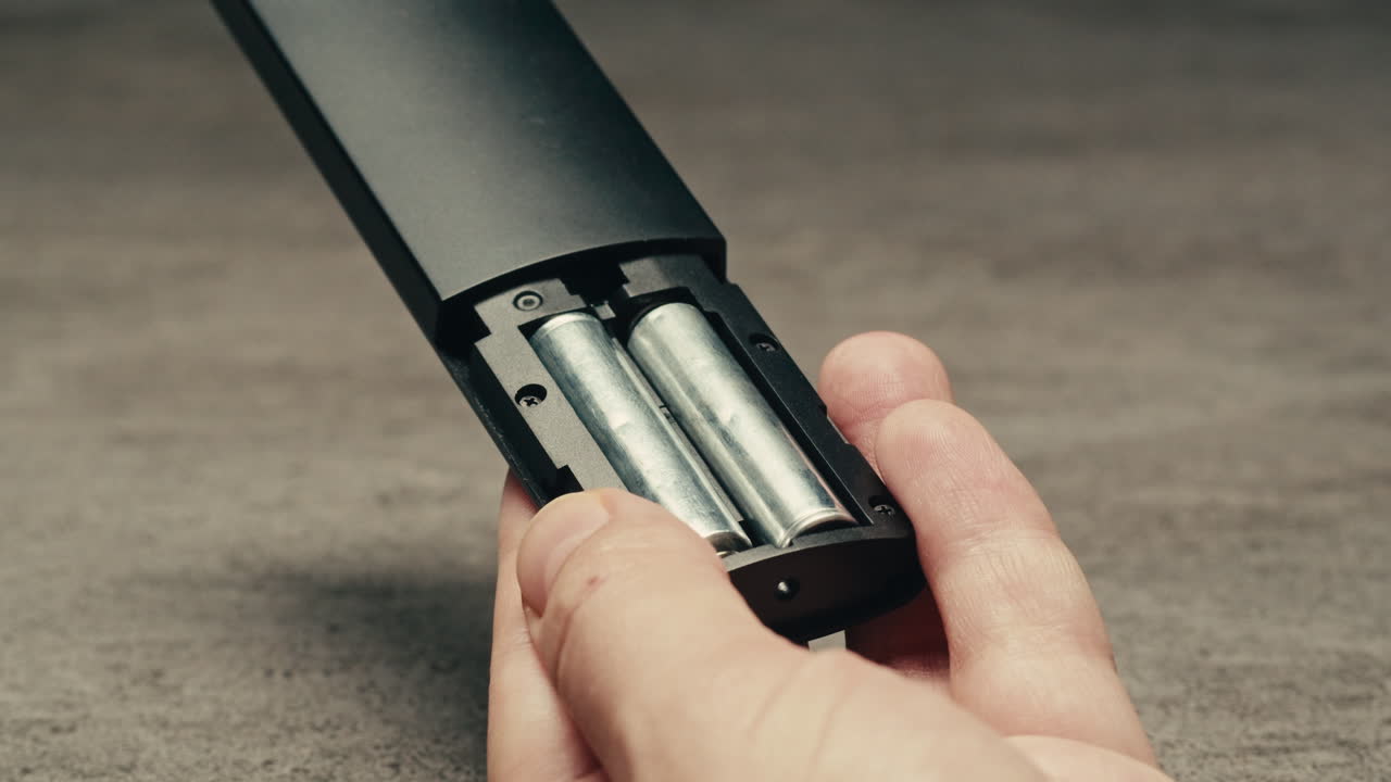 Adding silver batteries AA and AAA in remote controller TV close-up. Batteries are common in portable electronic devices. An AA battery is composed of a single electrochemical cell that may be either a primary battery or a rechargeable battery. Several different chemistries are used in their constru