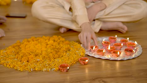 Indian-couple-decorating-home-with-Earthen-lamps