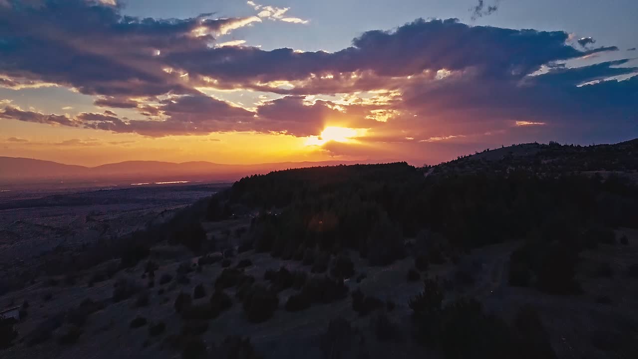 vuelo aéreo con drones sobre un bosque de pinos en la montaña al atardecer