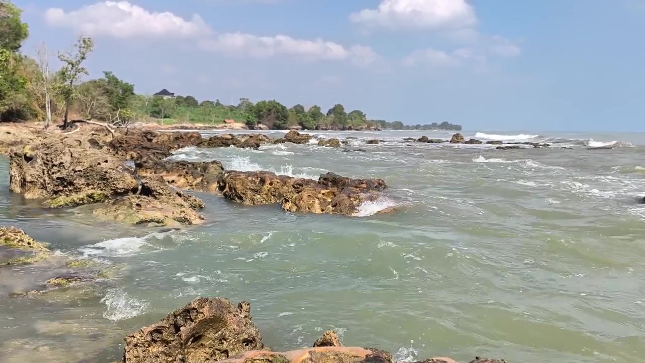 Havbølger som slår mot steinete strandlinje