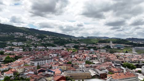 Aerial panorama of Guimarães cityscape with hills and cloudy sky in Portugal