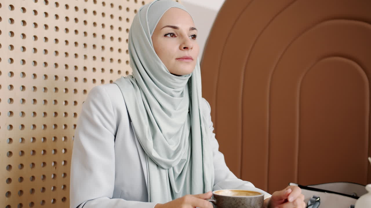 Woman in Hijab enjoying coffee at a cafe