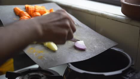 a south asian man cooking vegetables