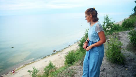 vacacionista caucásica caminando por el acantilado viendo la playa de karkle en lituania