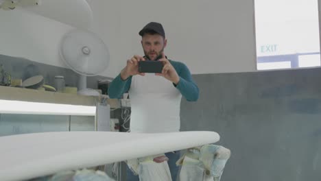 un hombre que hace tablas de surf en su taller