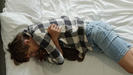 boy hugging a red panda on a bed