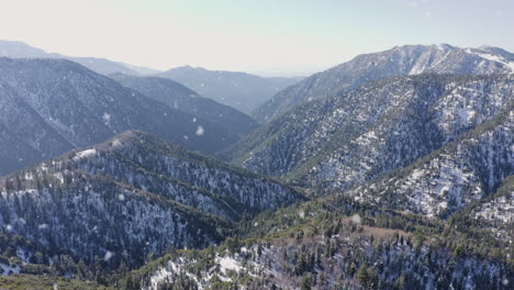 Amazing-Drone-Pullback-over-Snow-Covered-Mountains-and-Trees-during-Snowfall