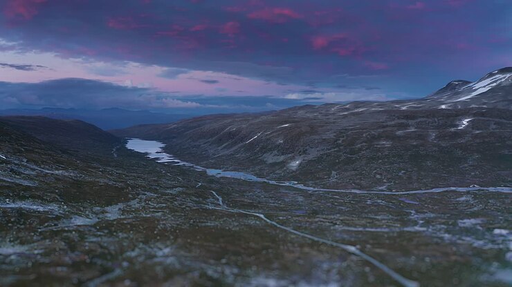 Ascesa sul Gamle Strynefjellsvegen con un magnifico tramonto blu e rosso sullo sfondo.