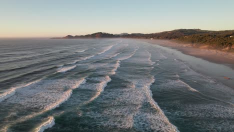 Entspannende-Wellen-Entlang-Der-Strandlinie-Bei-Sonnenuntergang,-4K-Drohnenaufnahme