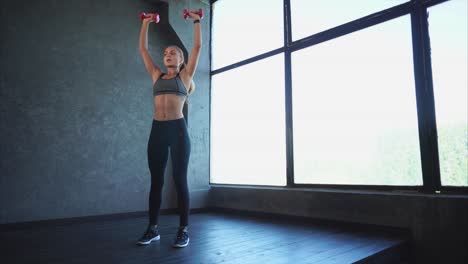 woman performing shoulder press exercise with dumbbells